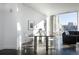 Sunlit dining area with dark floors, contemporary art, a minimalist table, and city views at 55 W 12Th Ave # 211, Denver, CO 80204