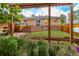 A large backyard with a lush garden, a wooden patio, and a well-manicured lawn at 4891 Depew St, Denver, CO 80212