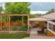 Landscaped backyard with a wooden pergola, outdoor kitchen, and seating area at 4891 Depew St, Denver, CO 80212