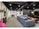 Spacious finished basement with exposed ceiling and a large sectional couch at 4891 Depew St, Denver, CO 80212