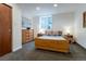 Bright bedroom featuring neutral walls, a window, and minimal wooden furniture at 4891 Depew St, Denver, CO 80212