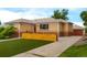Exterior shot of the home and detached garage featuring a well maintained lawn at 4891 Depew St, Denver, CO 80212