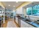 Bright kitchen featuring stainless steel appliances, light wood floors, white cabinets, and large windows at 4891 Depew St, Denver, CO 80212
