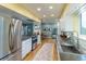 Updated kitchen with stainless steel appliances, stone countertops, white cabinets, and an open layout to the dining area at 4891 Depew St, Denver, CO 80212