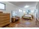 Spacious main bedroom with light hardwood floors, minimalist decor, and abundant natural light from multiple windows at 4891 Depew St, Denver, CO 80212