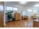 Main bedroom featuring natural light, bright white walls, hardwood floors and a potted green houseplant at 4891 Depew St, Denver, CO 80212