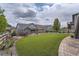 Lush backyard with a well-manicured lawn and stone accents, complete with stairs to an upper deck, perfect for outdoor living at 8133 Arapahoe Peak St, Littleton, CO 80125
