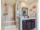 Bathroom with glass enclosed shower, seat, and vanity with storage at 8133 Arapahoe Peak St, Littleton, CO 80125