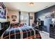 Bedroom with black furniture, desk, sports memorabilia, and a window with views at 8133 Arapahoe Peak St, Littleton, CO 80125