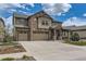 Charming two-story home with a stone and siding exterior, well-manicured lawn, and a three car garage at 8133 Arapahoe Peak St, Littleton, CO 80125