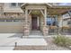 Inviting front porch with stone pillars, dark wood door, and a cozy seating area with charming decorations at 8133 Arapahoe Peak St, Littleton, CO 80125