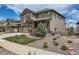 Charming two-story home with a stone and siding exterior, a covered porch, and landscaped front yard at 8133 Arapahoe Peak St, Littleton, CO 80125