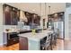 Kitchen with a large island, stainless steel appliances, dark cabinets, and hardwood floors at 8133 Arapahoe Peak St, Littleton, CO 80125