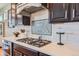Close-up of kitchen showcasing a gas stovetop, quartz countertops, and modern backsplash at 8133 Arapahoe Peak St, Littleton, CO 80125
