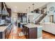 Open kitchen featuring a large island, dark cabinetry, stainless steel appliances, and hardwood floors at 8133 Arapahoe Peak St, Littleton, CO 80125