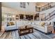 Spacious living room with two-story ceilings, a large sectional sofa, and open access to the kitchen at 8133 Arapahoe Peak St, Littleton, CO 80125