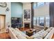 Cozy living room with a fireplace, large windows, a comfortable sectional sofa, and a view of the backyard at 8133 Arapahoe Peak St, Littleton, CO 80125