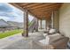 Charming covered patio with stone pillars, offering a relaxing seating area and stair access to the backyard, ideal for gatherings at 8133 Arapahoe Peak St, Littleton, CO 80125