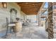Inviting covered patio with stone columns, featuring comfortable seating and string lights, perfect for outdoor relaxation at 8133 Arapahoe Peak St, Littleton, CO 80125