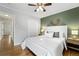 Bedroom features green accent wall, hardwood flooring, ceiling fan, and natural light from window at 1876 S Adams St, Denver, CO 80210