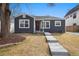 Charming single-story home featuring a dark exterior, well-manicured lawn and a concrete walkway at 1876 S Adams St, Denver, CO 80210