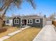 Charming house with well-maintained landscaping, dark siding and a long driveway to the detached garage at 1876 S Adams St, Denver, CO 80210