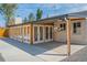 Wide view of the back patio featuring a wooden ceiling, multiple glass doors, and a concrete floor at 6935 W 16Th Ave, Lakewood, CO 80214