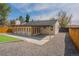 An aerial backyard view of the patio, detached garage, artificial grass, gravel and fencing at 6935 W 16Th Ave, Lakewood, CO 80214
