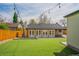 Expansive backyard features a well-manicured lawn, string lights, and a set of french doors at 6935 W 16Th Ave, Lakewood, CO 80214