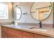 Bathroom featuring double sinks with modern fixtures, large mirrors, and a sliding door to closet at 6935 W 16Th Ave, Lakewood, CO 80214