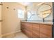 Bright bathroom featuring modern vanity with double sinks, round mirrors and wood-tone cabinetry at 6935 W 16Th Ave, Lakewood, CO 80214
