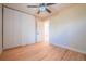 Bedroom featuring light hardwood floors, neutral walls, a ceiling fan, and a modern closet door at 6935 W 16Th Ave, Lakewood, CO 80214
