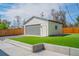 Modern detached two-car garage with gray door and white trim, set against a vibrant green lawn at 6935 W 16Th Ave, Lakewood, CO 80214