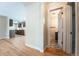 Hallway view with light wood floors leading to a kitchen and a bathroom with patterned tile at 6935 W 16Th Ave, Lakewood, CO 80214