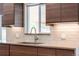 Modern kitchen featuring wood cabinets, stainless steel faucet, and white subway tile backsplash at 6935 W 16Th Ave, Lakewood, CO 80214