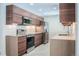 Contemporary kitchen featuring brown cabinetry, stainless steel appliances and light colored countertops at 6935 W 16Th Ave, Lakewood, CO 80214