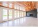 Bright room with wood ceiling, tiled floors, fireplace, and multiple glass doors to backyard at 6935 W 16Th Ave, Lakewood, CO 80214