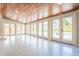 Spacious sunroom with multiple doors to the backyard, wood ceiling, and tiled floors at 6935 W 16Th Ave, Lakewood, CO 80214