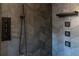 Close-up of the shower features dark herringbone tile and stylish shower fixtures with multiple spray options at 6935 W 16Th Ave, Lakewood, CO 80214