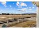 Backyard view of open field and distant mountains with white fence at 5035 Old Ranch Dr, Longmont, CO 80503