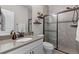 Modern bathroom showcasing a vanity with a light countertop and glass shower with brown trim and decorative shelving at 5035 Old Ranch Dr, Longmont, CO 80503