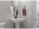 Powder room featuring a pedestal sink, round mirror, and fresh white paint at 5035 Old Ranch Dr, Longmont, CO 80503