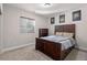 Bedroom features a sleek, dark-stained wood bed frame and carpet floors. Cozy room is lit by natural light at 5035 Old Ranch Dr, Longmont, CO 80503