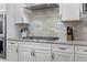 A modern kitchen featuring a stainless steel range hood, granite countertops, and white cabinets at 5035 Old Ranch Dr, Longmont, CO 80503