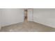A basement room with neutral carpet and a door leading to another room at 2026 S Pitkin St, Aurora, CO 80013
