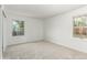 An empty bedroom featuring neutral carpet, white walls, and natural light from two windows at 2026 S Pitkin St, Aurora, CO 80013