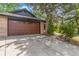A brick garage with a brown door and a paved driveway, offering ample parking at 2026 S Pitkin St, Aurora, CO 80013