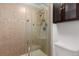 A tiled shower with a glass door, built-in shelving, and an overhead light at 2026 S Pitkin St, Aurora, CO 80013