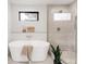 Spa-like bathroom featuring a modern soaking tub and glass-enclosed shower at 2391 King St, Denver, CO 80211
