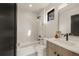 Contemporary bathroom with a tub-shower combo, sleek vanity, and dark accents at 2391 King St, Denver, CO 80211